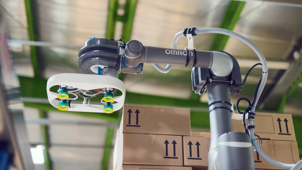 Close-up of collaborative palletizer gripper handling cartons