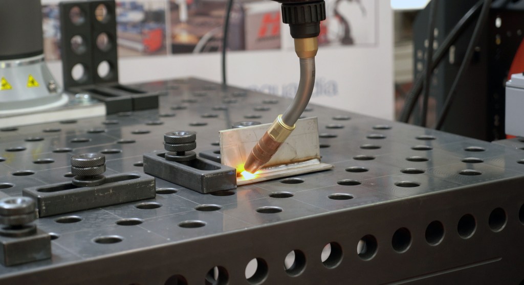Cobot performing automated welding on steel parts