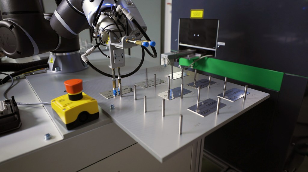 Collaborative robot automating laser marking machine tending