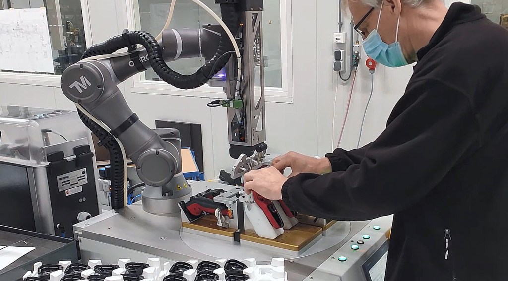 Operator collaborating with OMRON TM5-700 cobot for assembly automation in electric shaver manufacturing_cropped