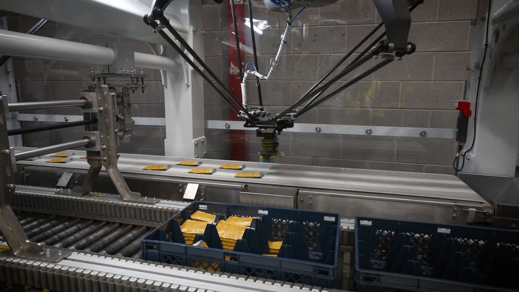Robotic arms implementing automated packaging solutions in a factory setting