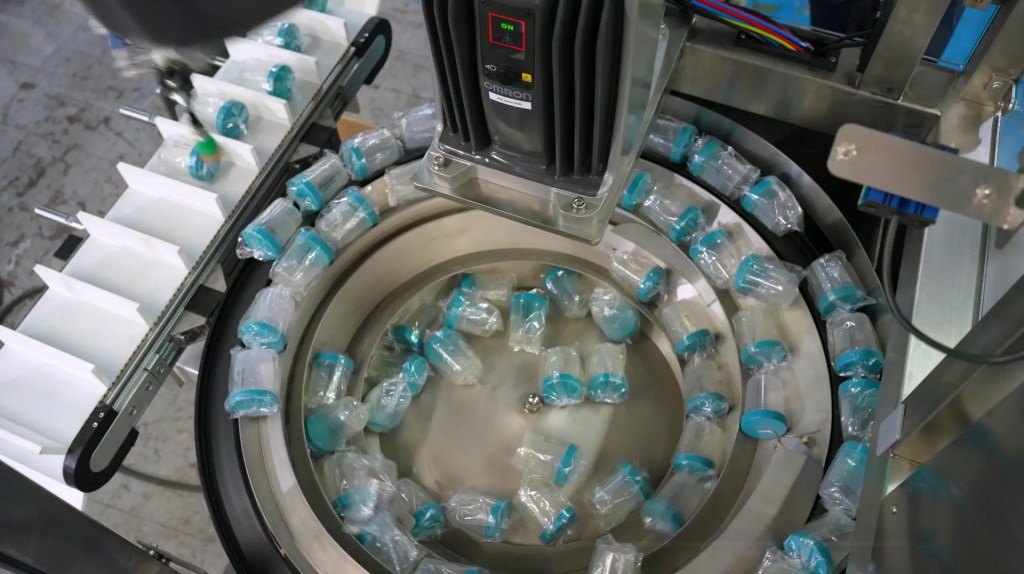 Circular pick-and-place system for robotic end-of-line packaging of medical diagnostic bottles