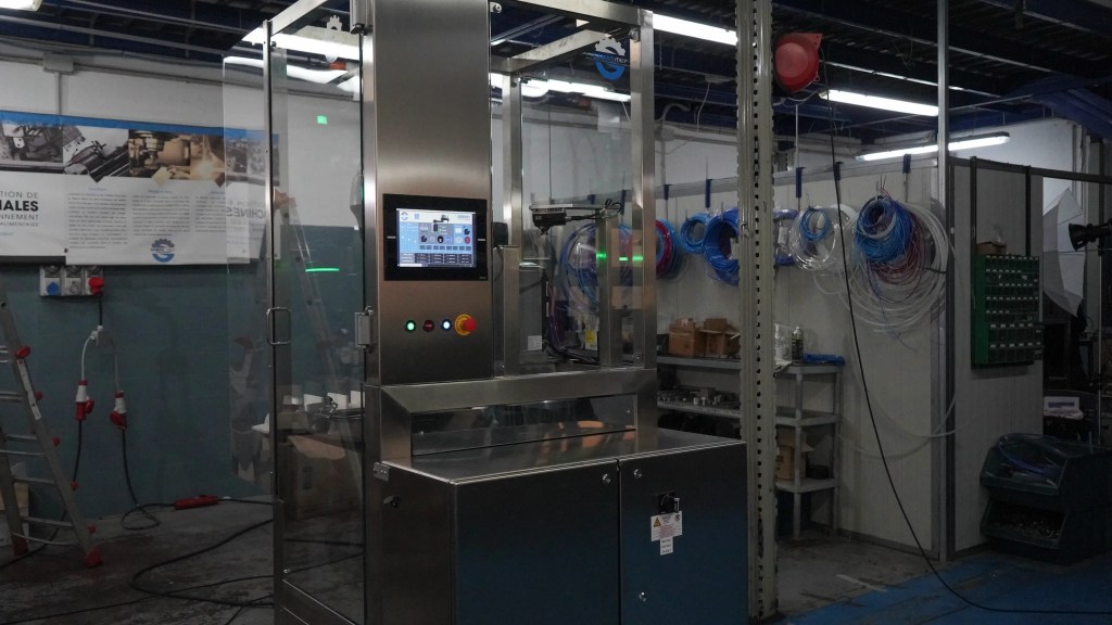 Enclosed Samas automation cell for bottle feeding and packaging operations