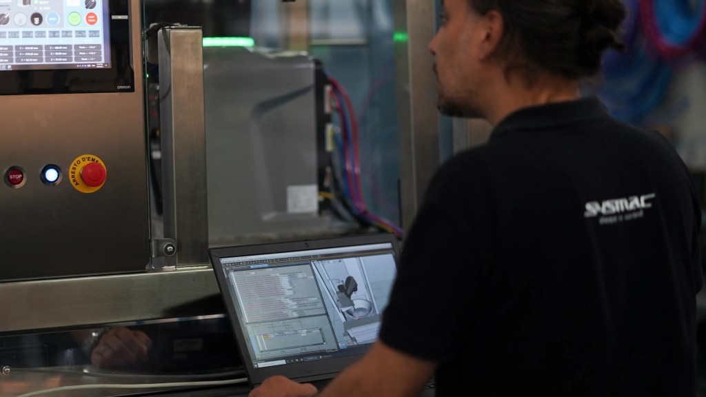 Engineer programming the Samas robotic cell with Sysmac software