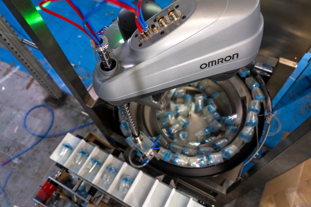 OMRON robot handling bottles in a robotic end-of-line packaging application